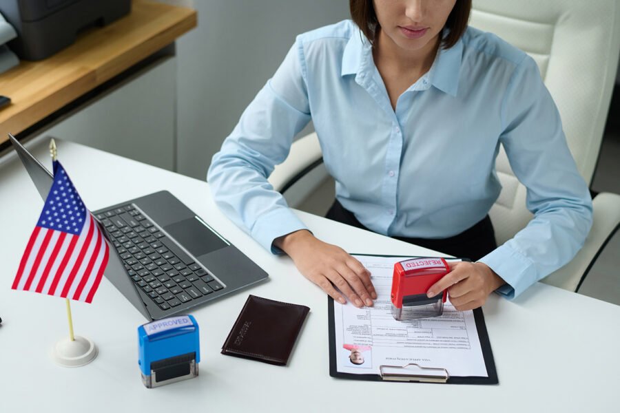 High angle view of professional specialist rejecting visa for tourist putting stamp on document