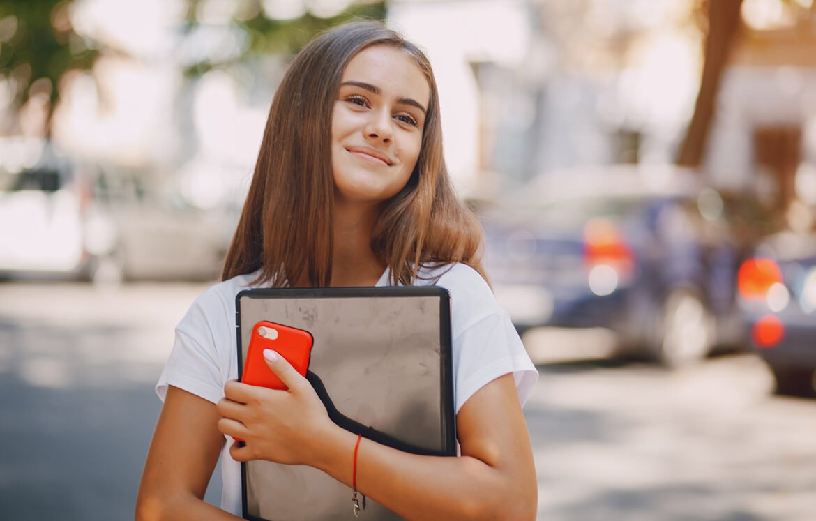 beautiful and stylish girl wallking in the summer city with phone and laptop