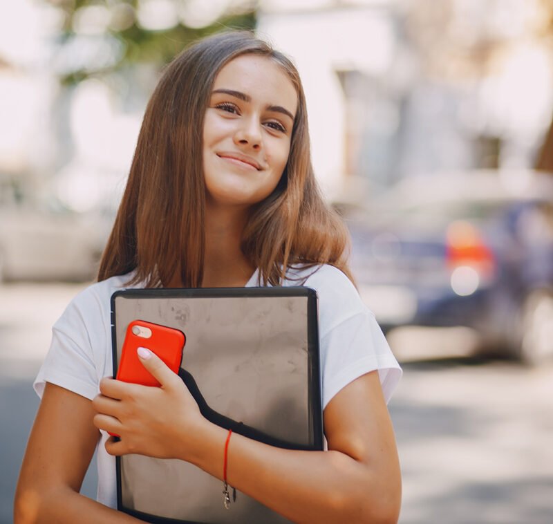 beautiful and stylish girl wallking in the summer city with phone and laptop