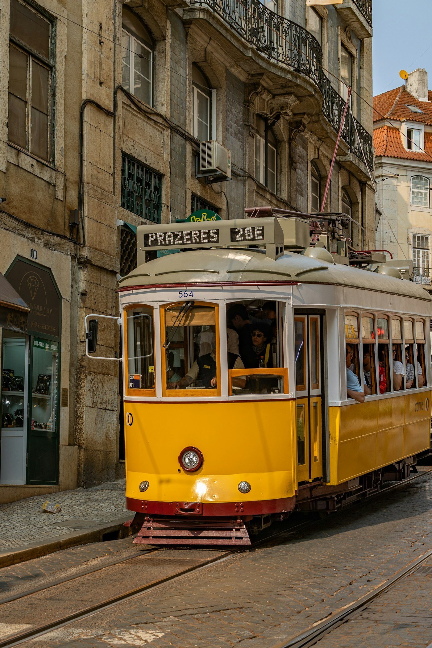 Lizbon sokaklarında sarı tramvay ve tarihi yapılar